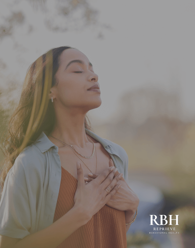 A woman takes a calming breath during mental health treatment in New Jersey.